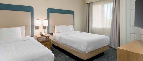 A hotel room with two beds, a nightstand with a phone, and a large window with curtains.