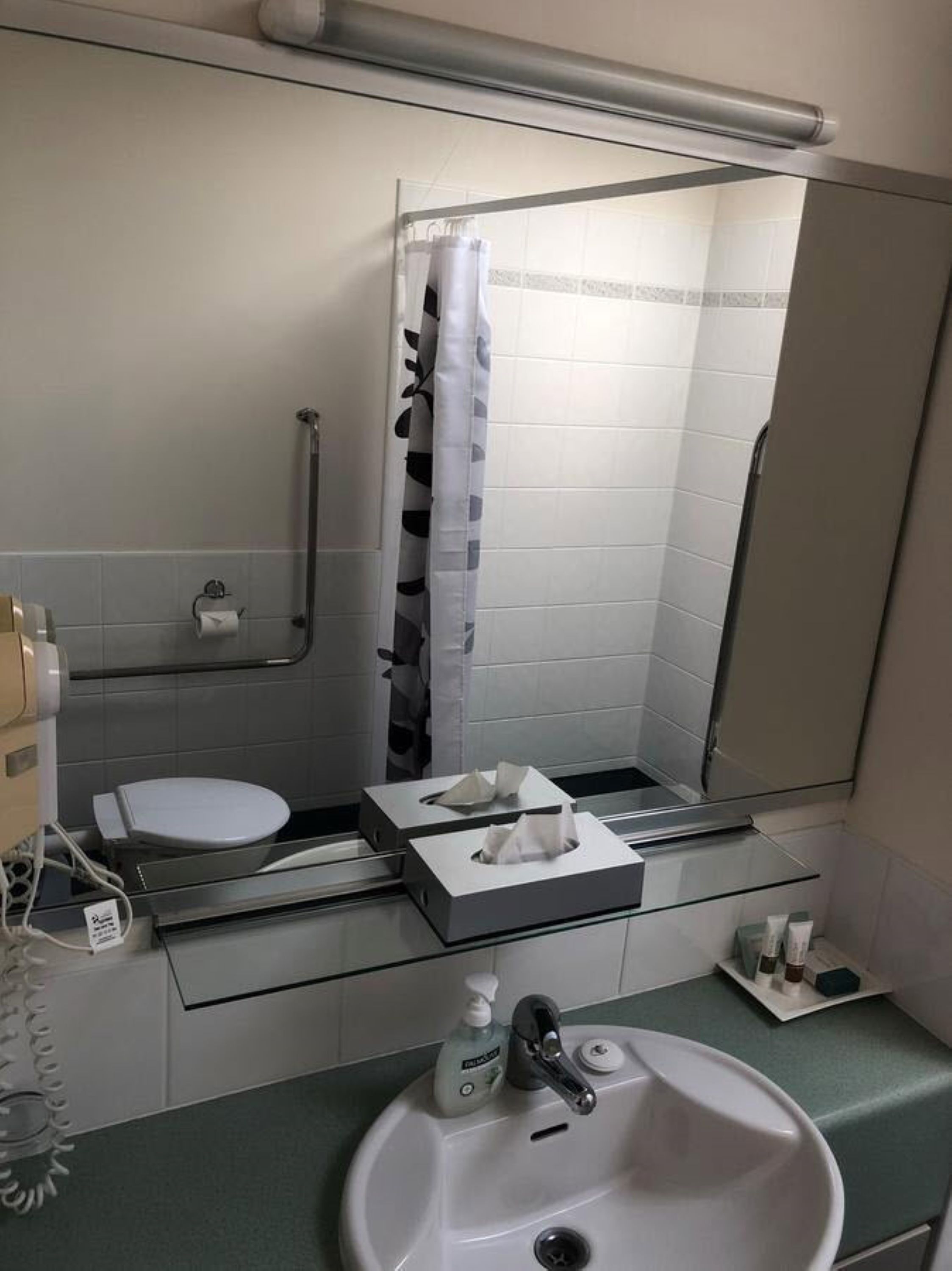 Ein Badezimmer mit Toilette, Waschbecken und Duschbereich.