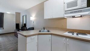A compact hotel room with a kitchenette, including a microwave, sink, and stove. - Extended Stay America Suites Fremont Warm Springs (Fremont)