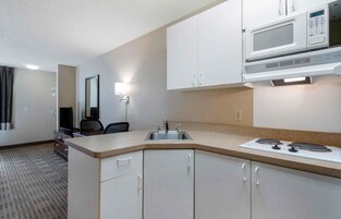 Habitación de hotel compacta con kitchenette, que incluye microondas, fregadero y estufa.