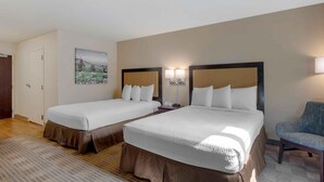 A hotel room with two beds, a chair, a painting on the wall, and a lamp. - Extended Stay America Suites Fremont Warm Springs (Fremont)