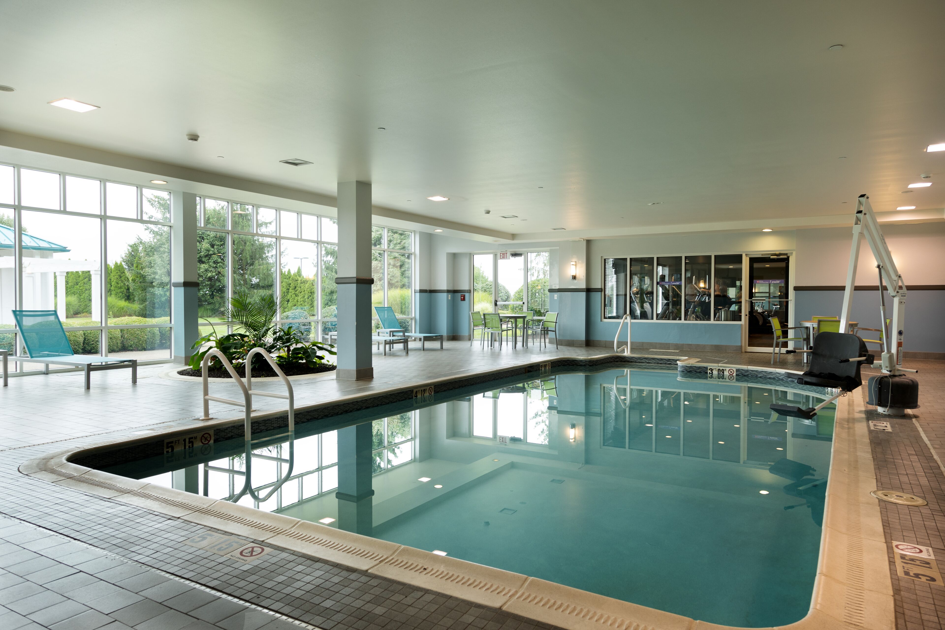 Una piscina techada, sillones reclinables de piscina