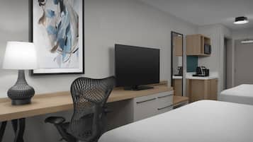 A modern hotel room with a bed, a desk with a computer, a chair, a TV, a lamp, a mirror, and a microwave.