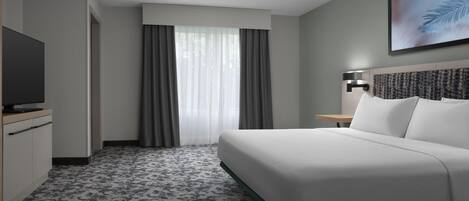 Ein Hotelzimmer mit einem Bett, einem Fernseher, einem Nachttisch und einem Fenster mit Vorhängen.