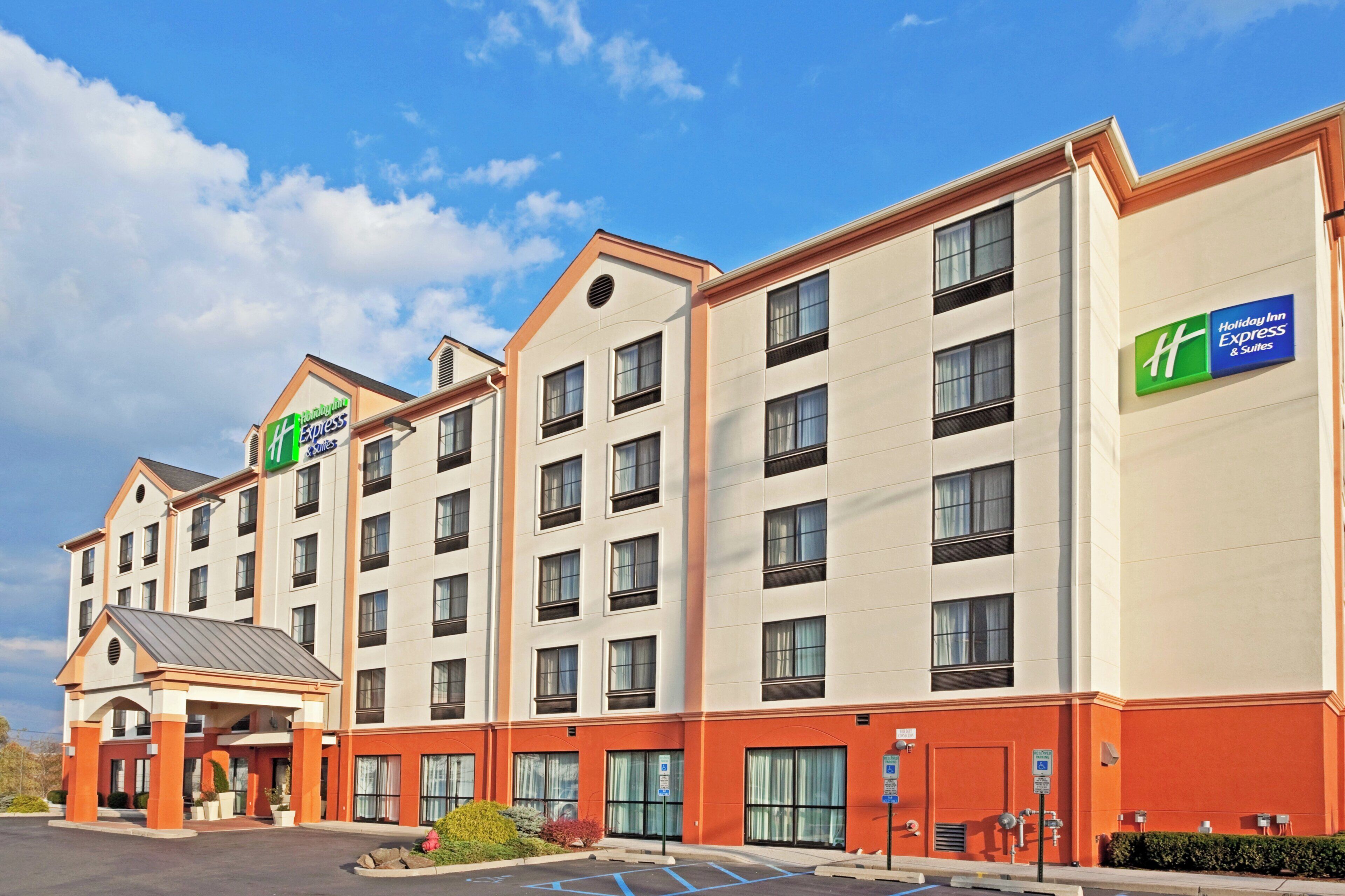 A multi-story Holiday Inn Express building with a flat facade, large windows, and a parking lot in front.