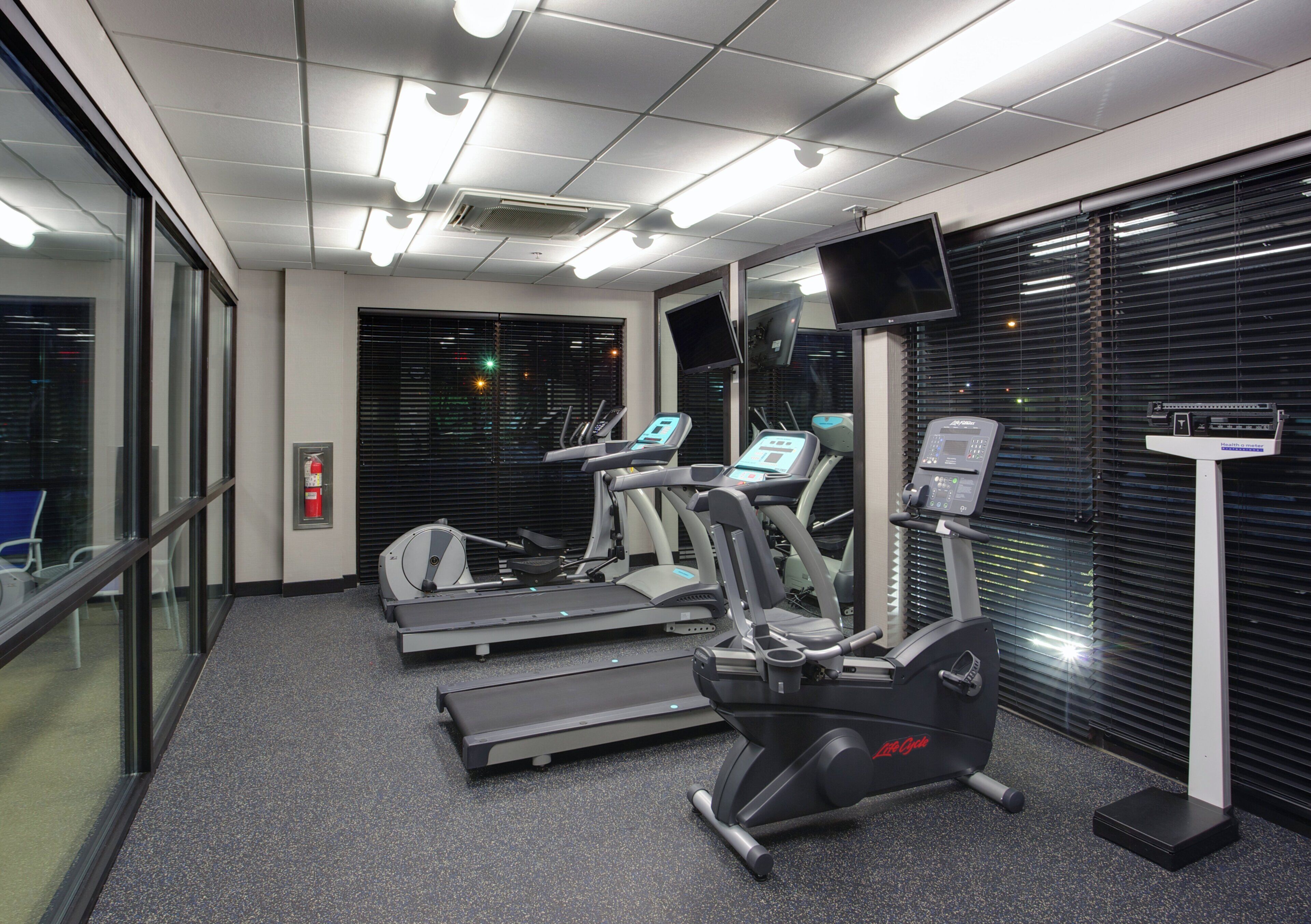A fitness center with treadmills, elliptical machines, and a stationary bike.