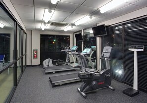 A fitness center with treadmills, elliptical machines, and a stationary bike.
