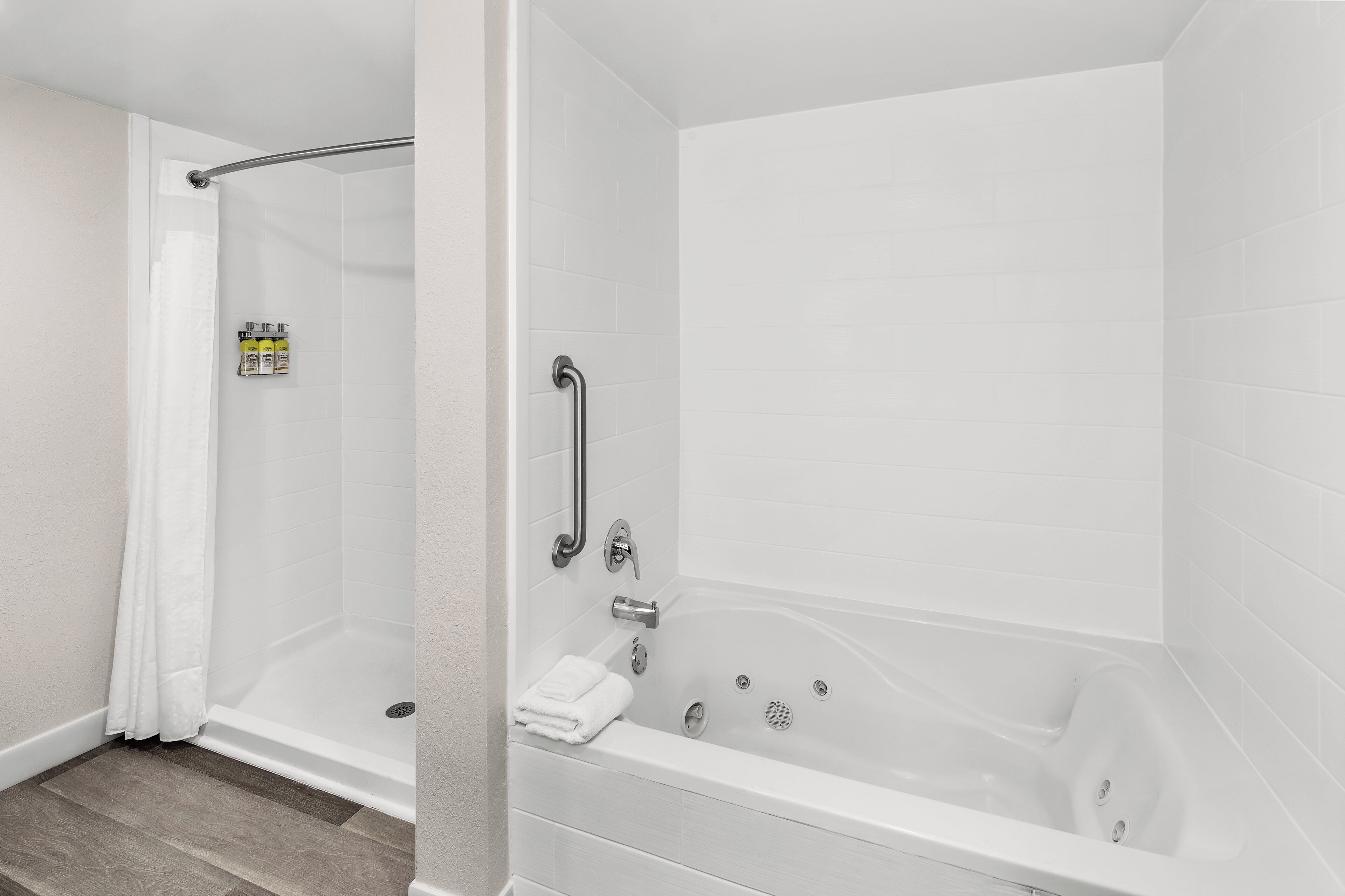 A modern bathroom with a walk-in shower, a bathtub, and a toilet.