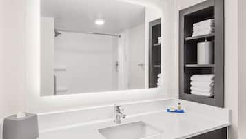 Une salle de bain moderne avec un grand miroir, un lavabo et un porte-serviettes.