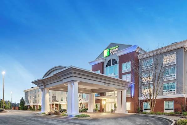 A Holiday Inn Express & Suites with a covered entrance and a clear sky.