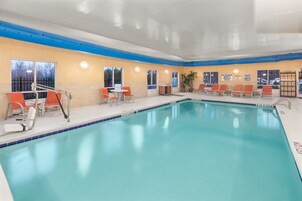 Una piscina techada, sillones reclinables de piscina