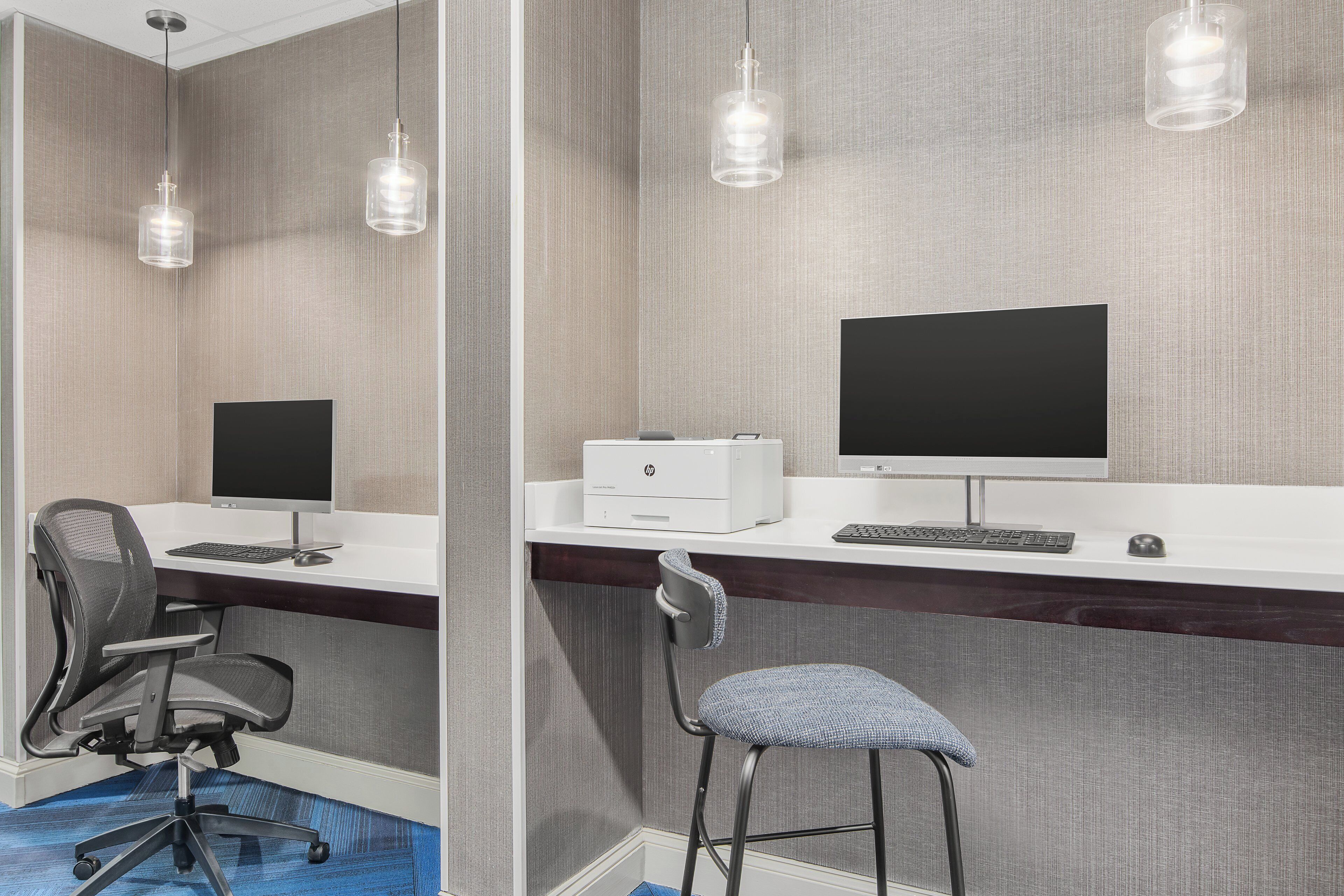 A modern office space with two desks, computers, and office chairs.