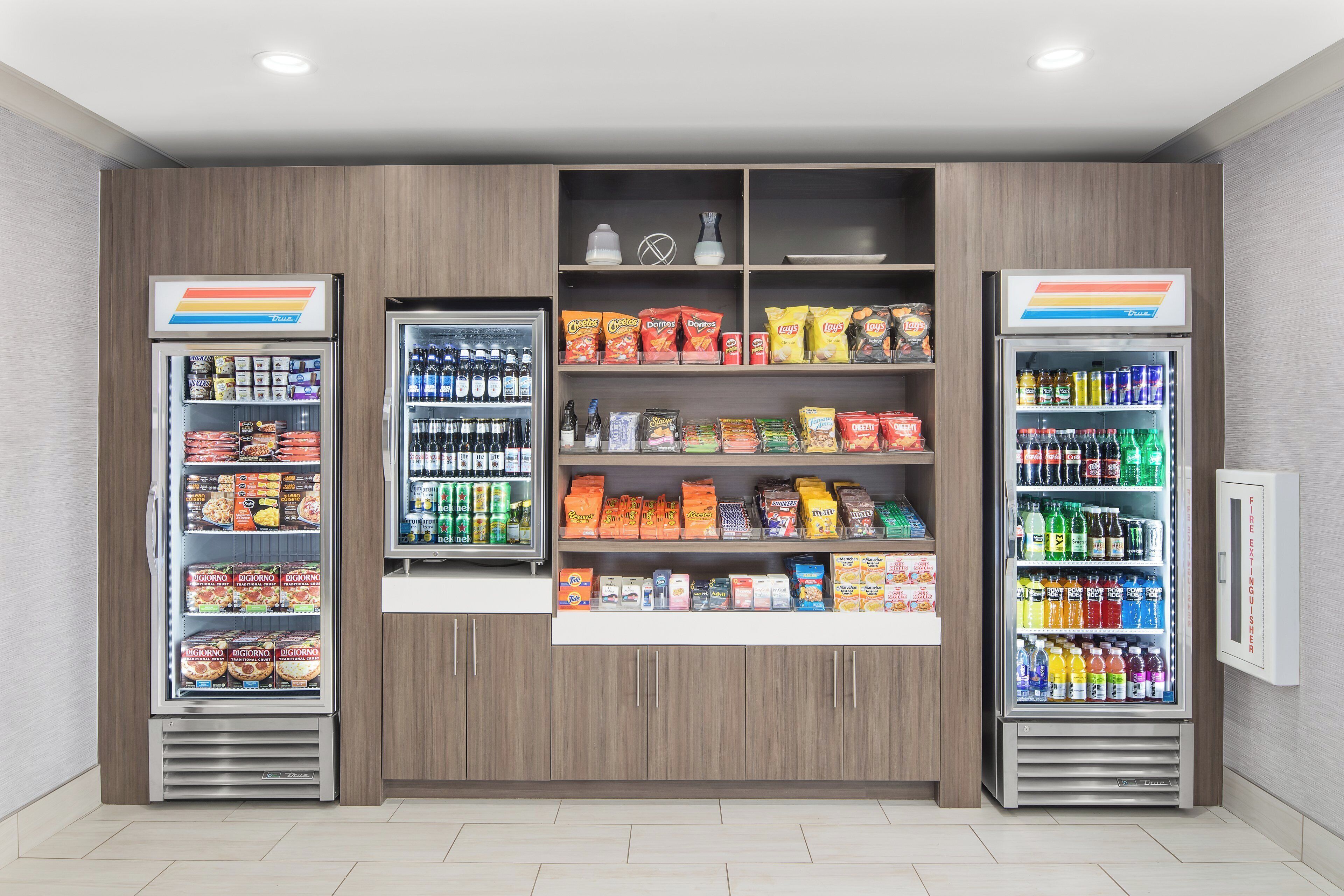 A vending machine area with snacks, beverages, and a fire extinguisher.
