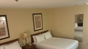 A hotel room with two single beds, a nightstand with a lamp, a framed picture on the wall, and a mirror. - Holiday Inn Express Las Vegas-Nellis by IHG (Las Vegas)