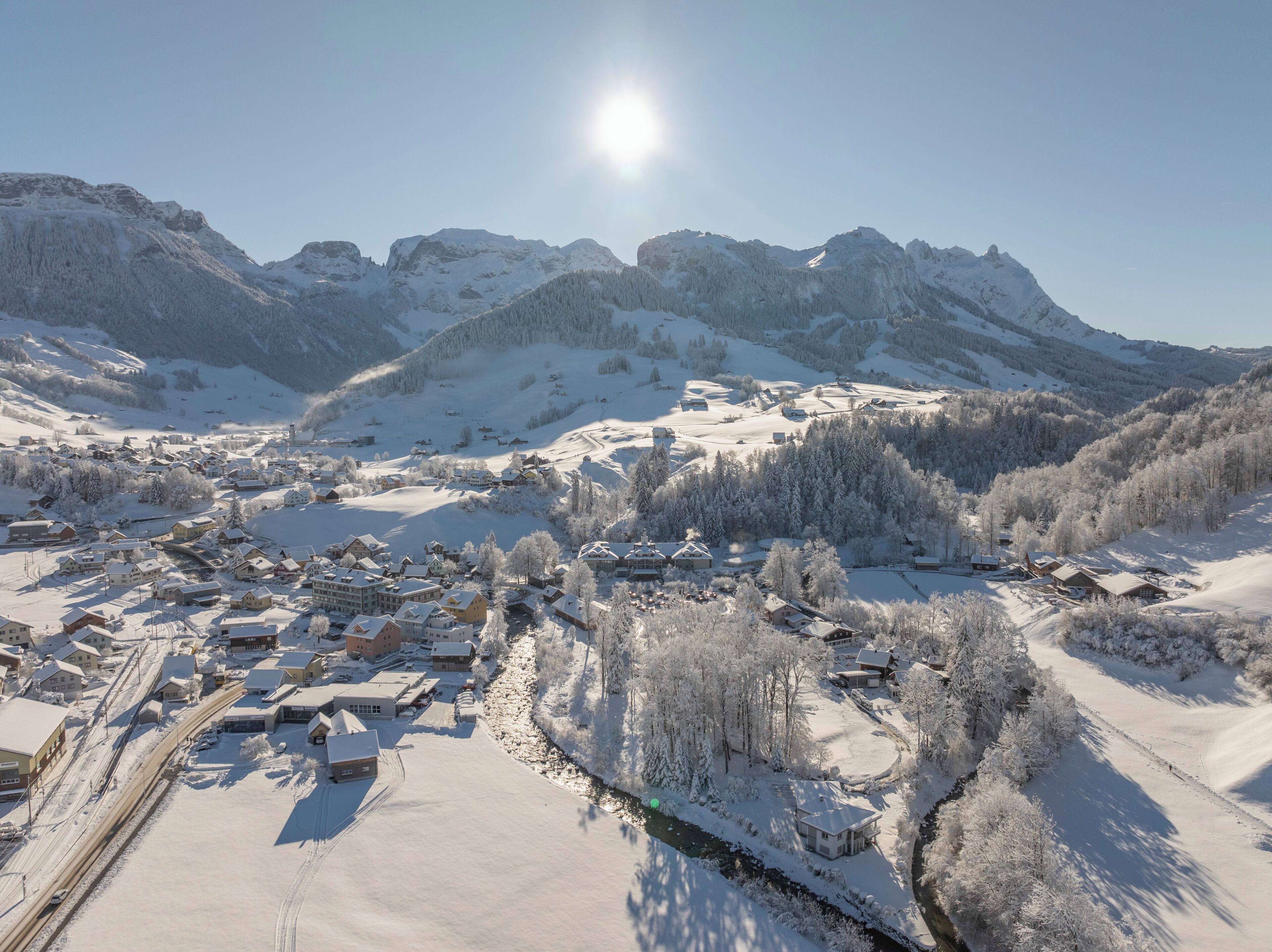 Un pueblo cubierto de nieve con edificios y un río.