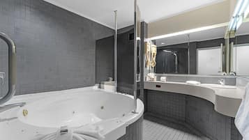 A modern bathroom with a freestanding bathtub, a large mirror, and a vanity with a sink.