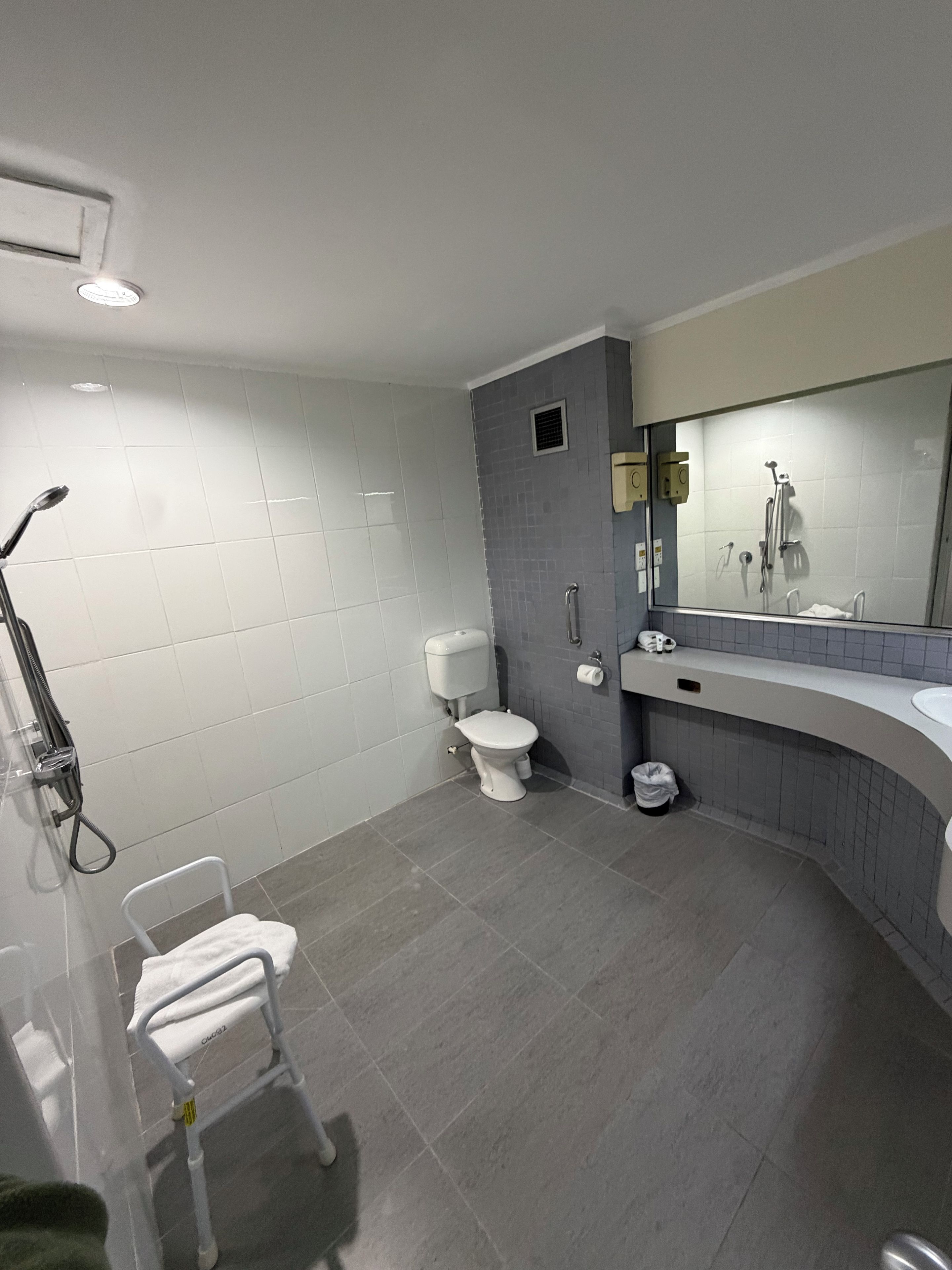 A modern bathroom with a toilet, shower, and sink.