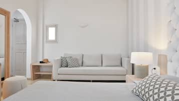 Une chambre à coucher moderne avec un lit, un canapé, une table de chevet et une lampe.