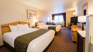 A hotel room with two beds, a desk, a TV, and a window with curtains. - Crystal Inn Hotel & Suites Great Falls (Great Falls)