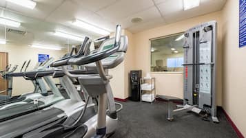 A hotel fitness center with treadmills, a weight machine, and a water cooler.