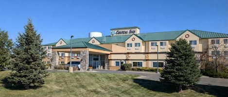 Un hotel con techo verde, varios pisos y un letrero que dice "Crystal Inn".