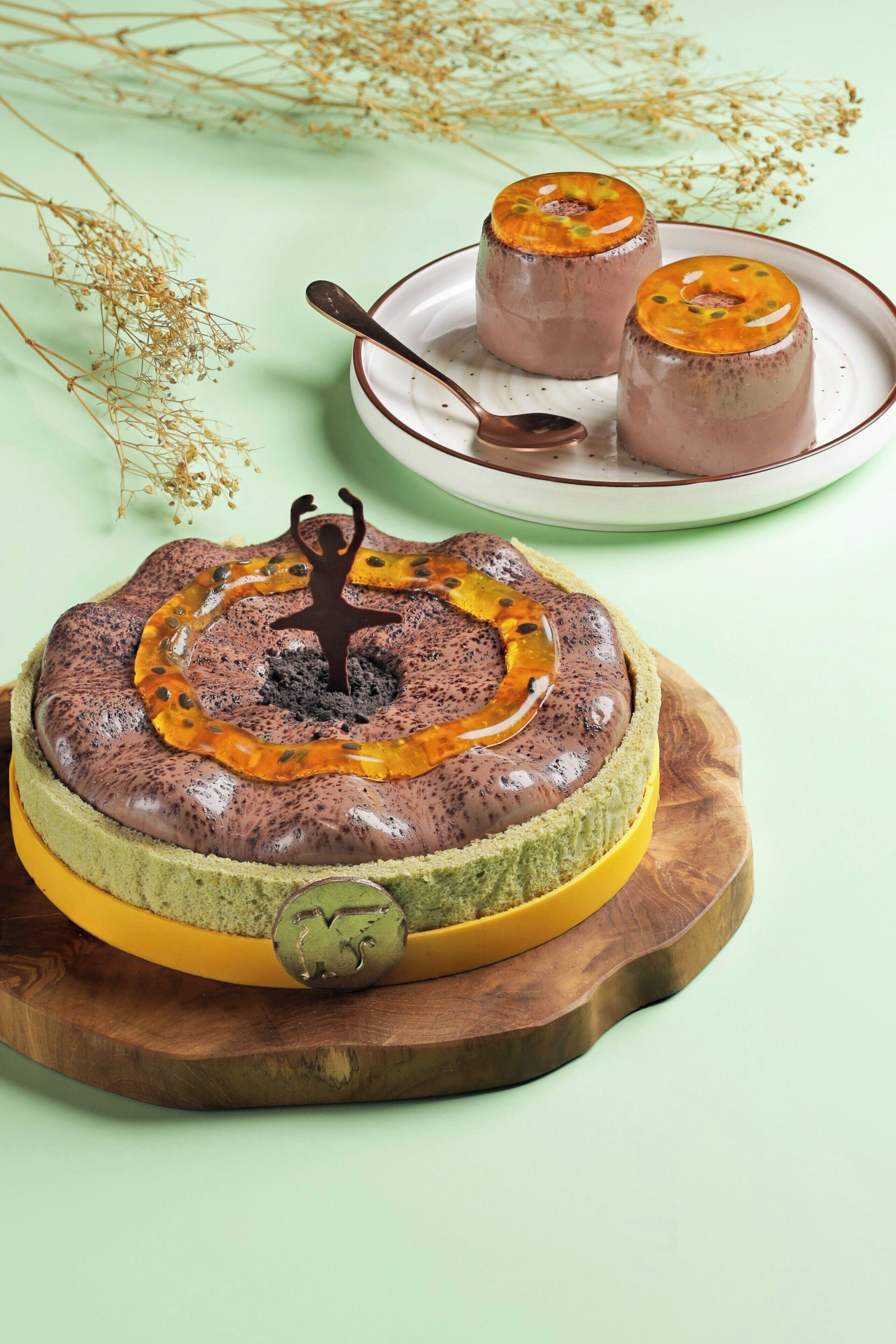 A chocolate lava cake with a caramelized top, served on a wooden board with a spoon.
