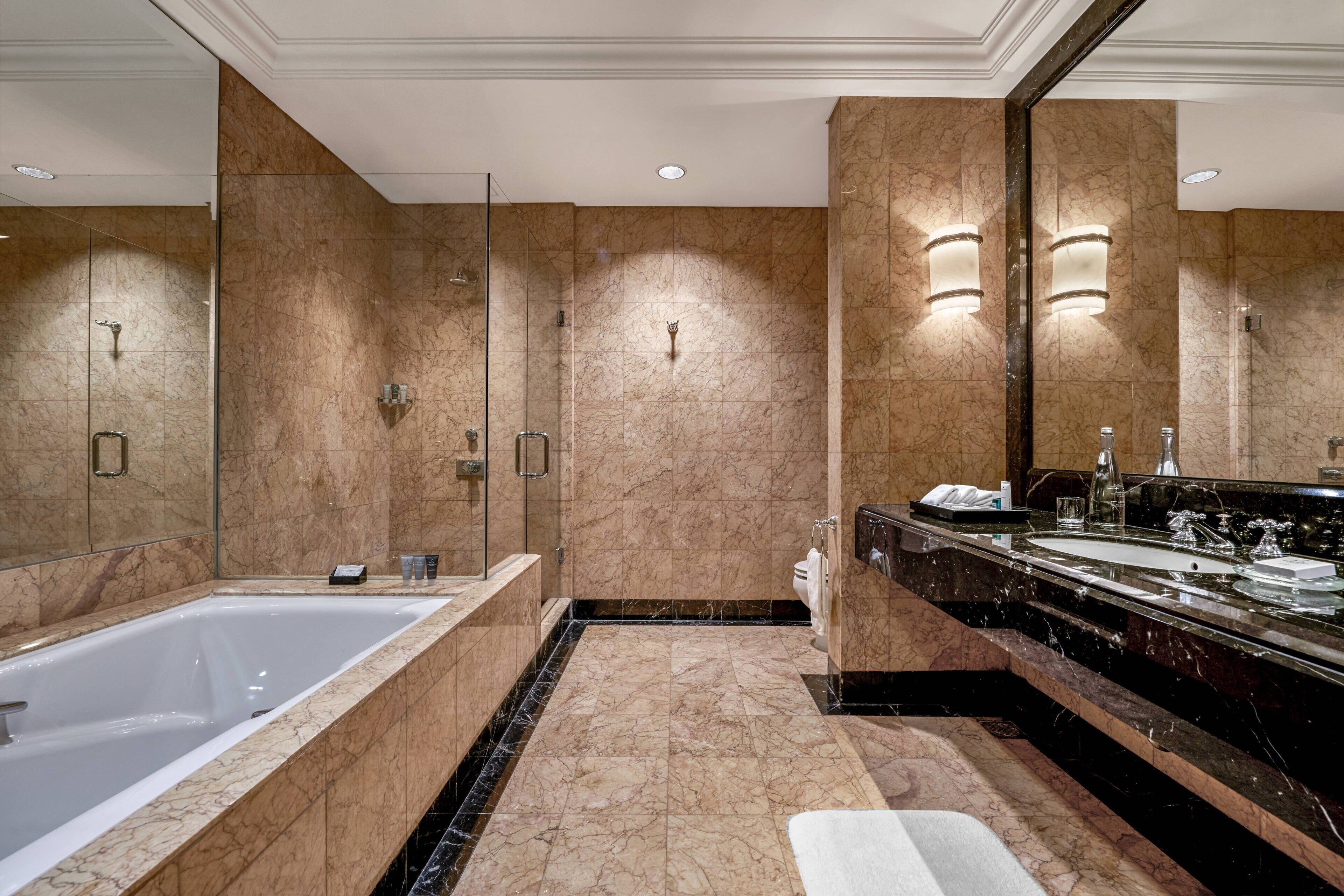 Un baño moderno con una bañera grande, una zona de ducha separada y un lavabo con espejo.