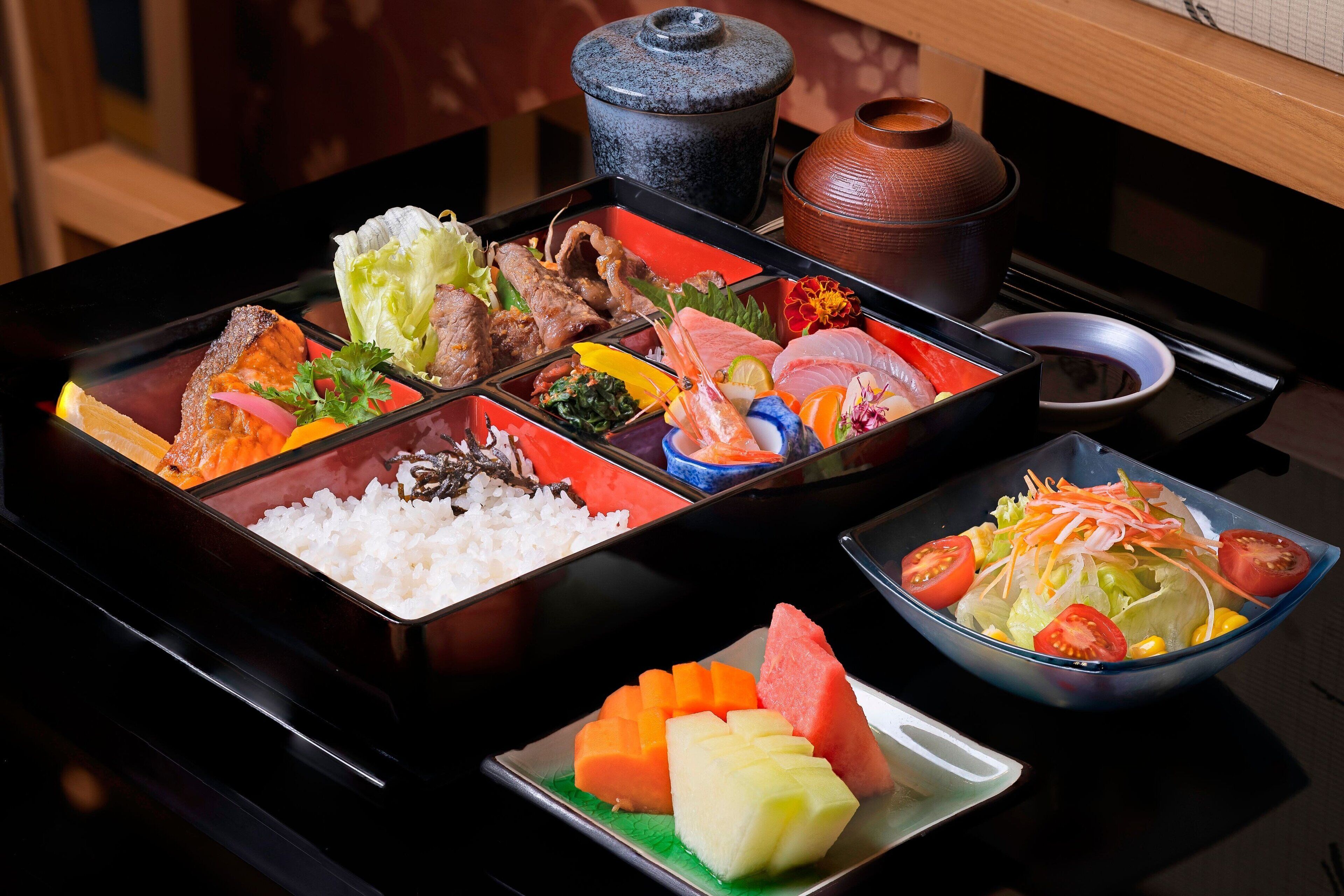 A traditional Japanese meal setup with various dishes including rice, fish, and vegetables.