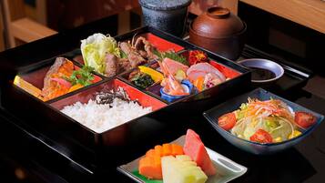 A traditional Japanese meal setup with various dishes including rice, fish, and vegetables.