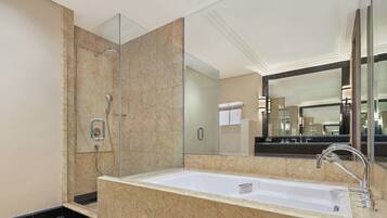 Une salle de bain moderne avec un grand miroir, une baignoire et une douche.