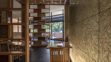Un interior moderno con muebles de madera, una división de vidrio y vistas a la vegetación exterior.