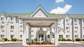 A multi-story hotel with a covered entrance and a fountain. - Stay Express Inn & Suites Atlanta (Union City)