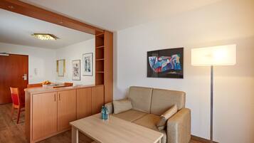 Een moderne woonkamer met een bank, een eettafel en een keukenhoek.