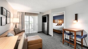 A hotel room with a sofa, a small table, a desk, and a bed.