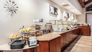 A buffet setup with various food items, a clock, and a coffee machine. - Residence Inn by Marriott Springfield (Springfield)