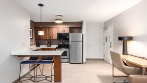 A modern kitchen with a central island, bar stools, a dining table, and a bar area. - Residence Inn by Marriott Springfield (Springfield)