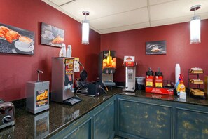A coffee shop interior with a red wall, coffee machines, and a menu board.