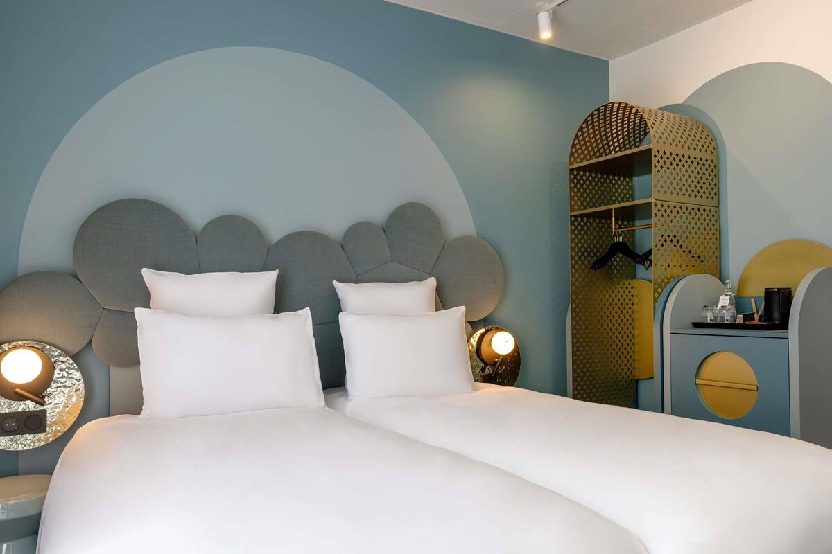 A bedroom with a large bed, two bedside tables, a wardrobe, and a mirror.