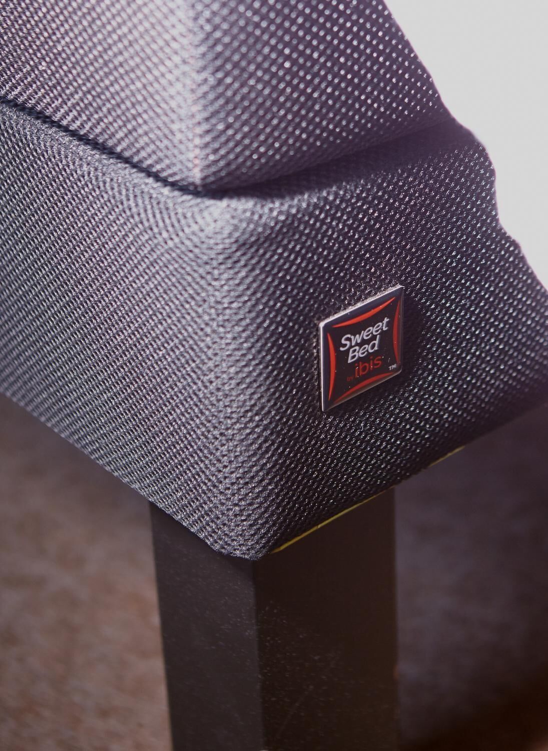 A close-up of a black textured fabric with a label reading "Sweet Bee".
