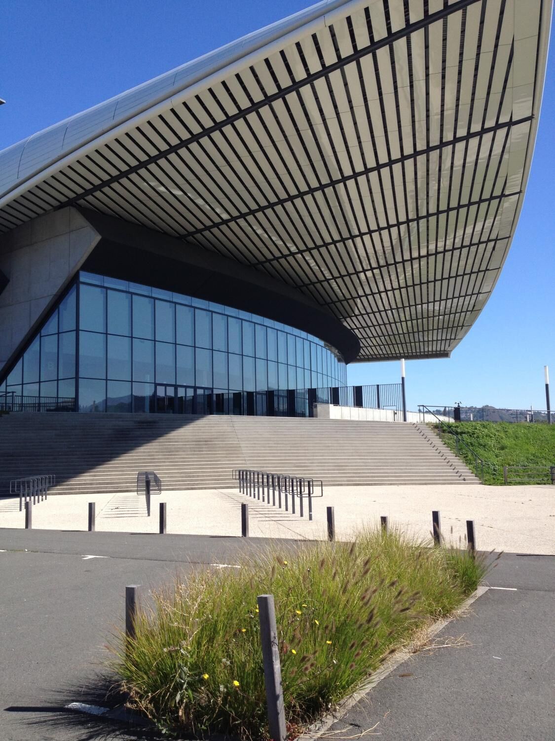 A modern building with a curved roof and large glass windows.