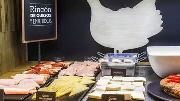 A cheese and cured meat display with labels for different types.