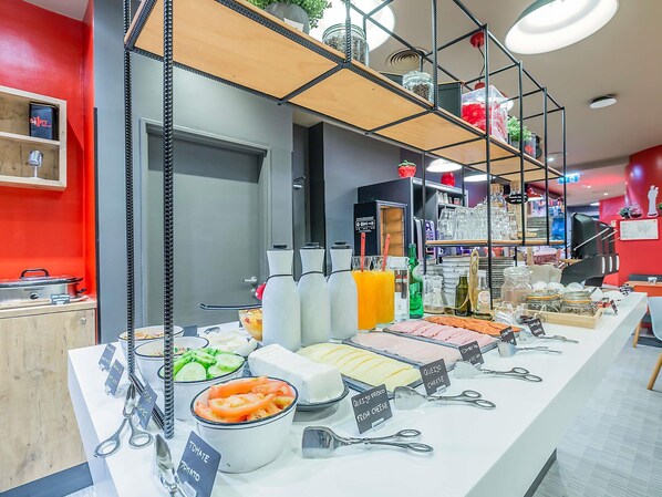 Una mesa de buffet con diversos alimentos y utensilios.