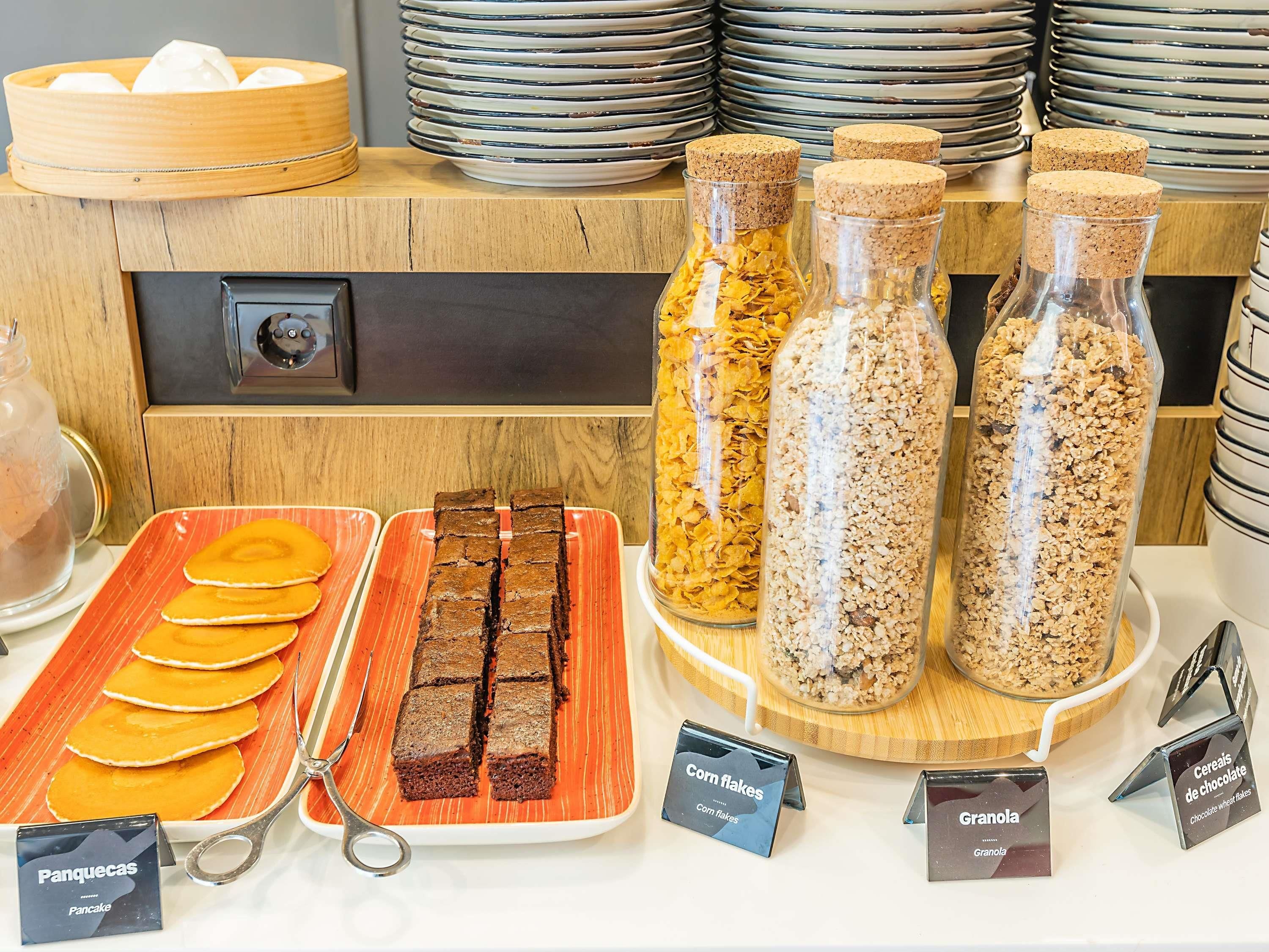 Un buffet de petit-déjeuner proposant une variété d'aliments et d'étiquettes explicatives.