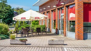 A restaurant with outdoor seating and a brick facade.