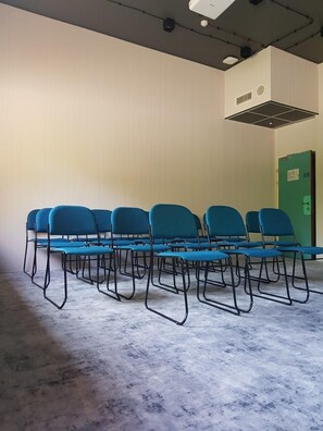 Conference room with a row of chairs and a green door.
