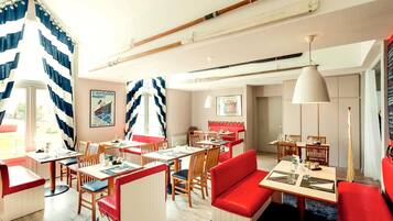 A restaurant with wooden furniture, red seating, and a nautical-themed decor.