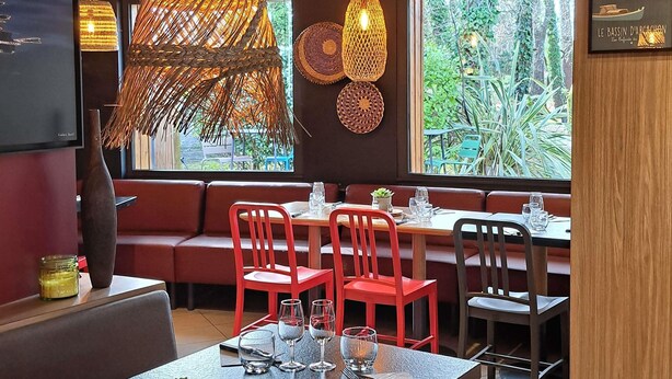 Un restaurante con un espacio de estar acogedor, que incluye un banco y mesas con sillas.