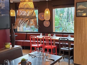 Un restaurant doté d’un espace salon accueillant, comprenant un banc et des tables avec des chaises.