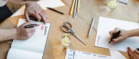 A group of people at a table with documents, pens, and a glass of water.