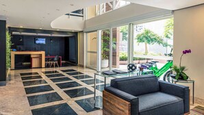 A modern lobby with a reception desk, seating area, and a view of the outdoors. - Lummina Ibirapuera São Paulo (Sao Paulo)